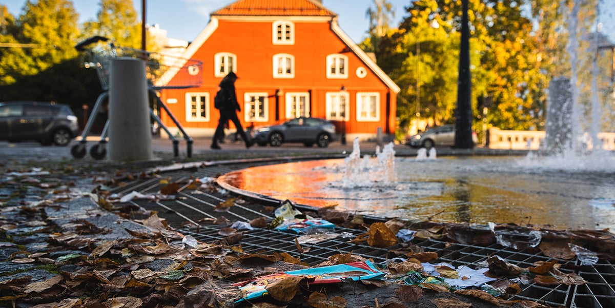 Bild på ett torg och en fontän med skräp på marken