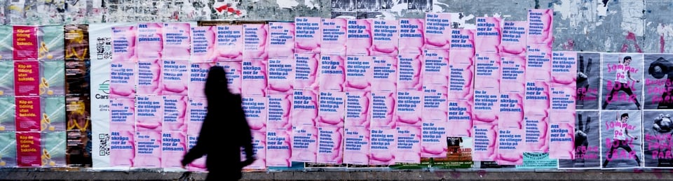 En affischvägg med budskap med skuggfigur lila/rosa