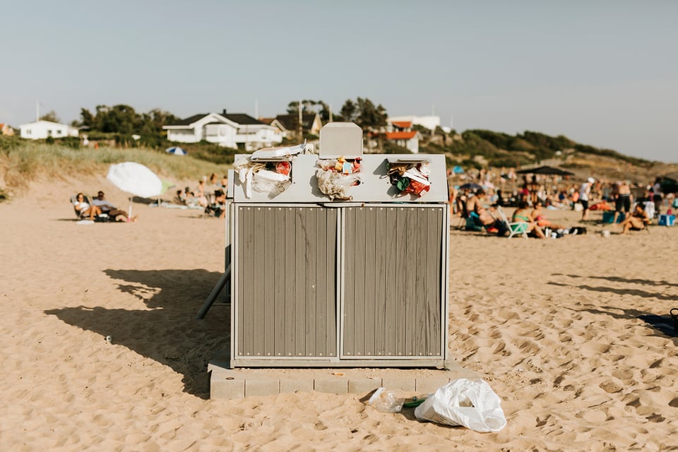 Strand med överfull papperskorg