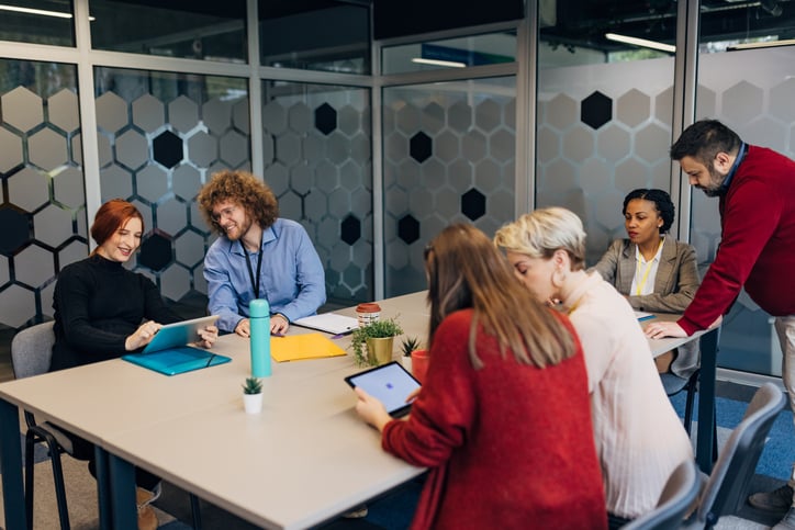 Kollegor runt ett mötesbord som pratar