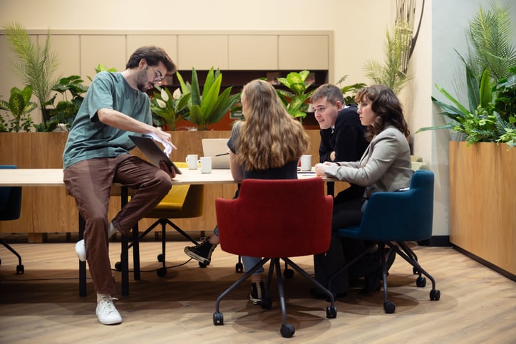 Kollegor runt ett mötesbord som pratar